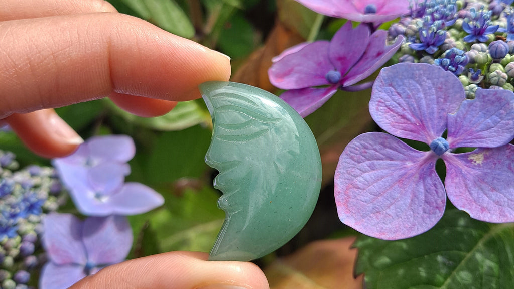 image of a green aventurine moon face carving. this healing crystal is available at dumi's crystals