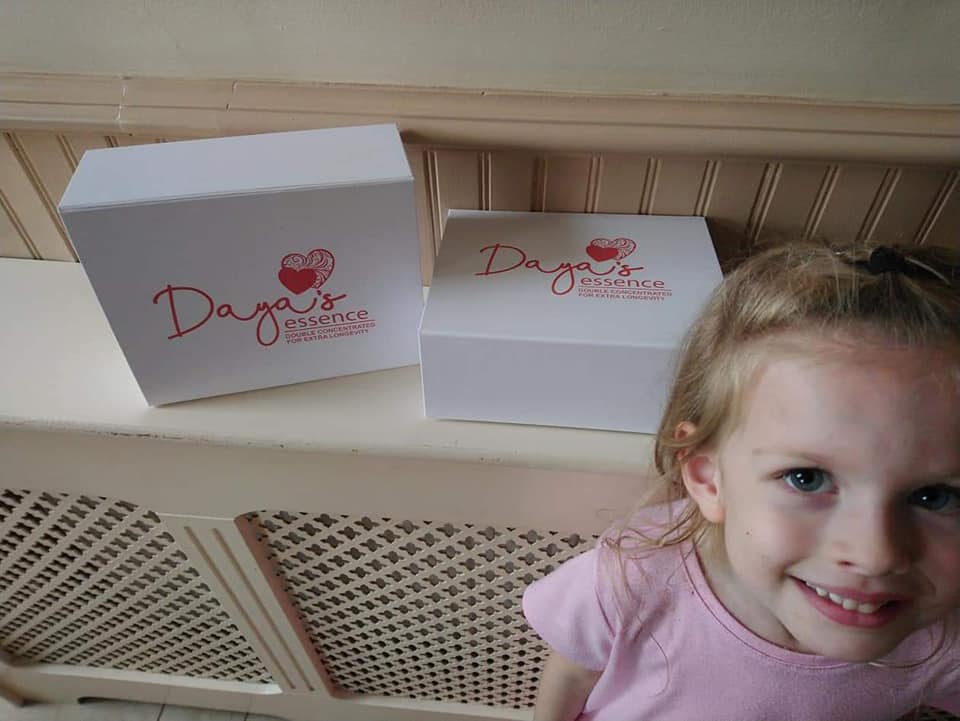 Daya's Essence smiling girl with branded boxes