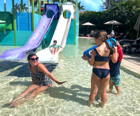 mom on waterslide with kids on vacation