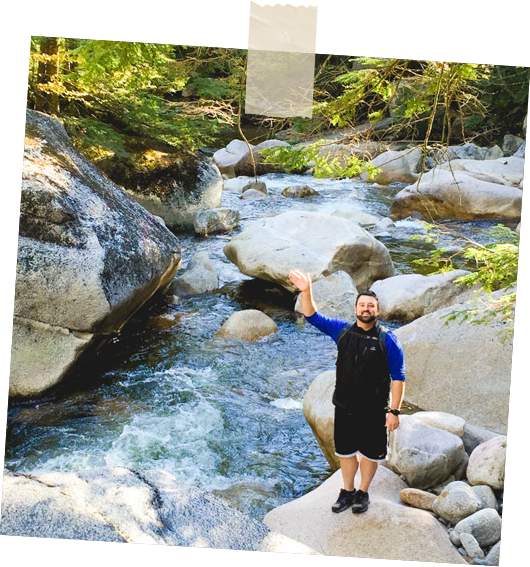 A man standing on a rock next to a river