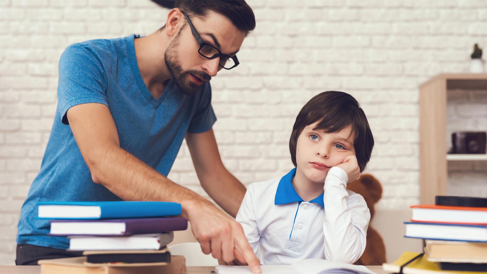 Father teaches son to study, child feels so boring