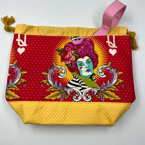 A red and yellow patterned fabric bag for craft projects.