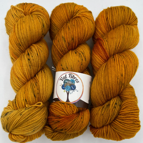 A skein of hand-dyed golden brown yarn by Val Fibres