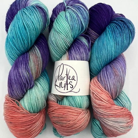 Malibu Barbie, a blue, purple, and pink variegated skein of hand-dyed yarn by Partea Knits