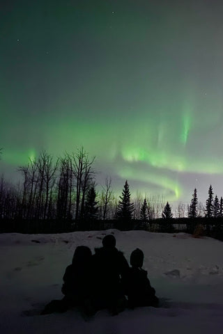 A family watching the Northern Lights at night