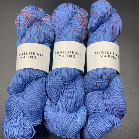 A soft blue skein of yarn with a hint of pink