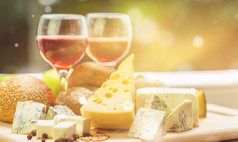 sunlit wine glasses, wine and cheese in golden light