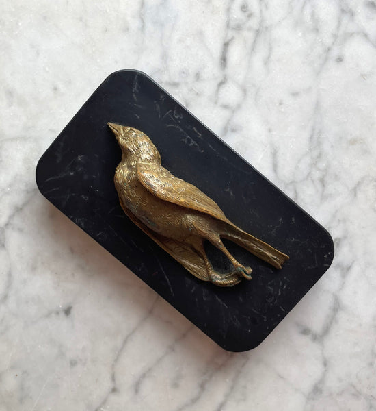 19th century paperweight consisting of a life-sized dead bird made of bronze mounted onto a black marble base.