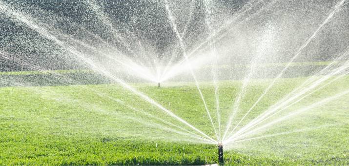 two sprinklers watering grass