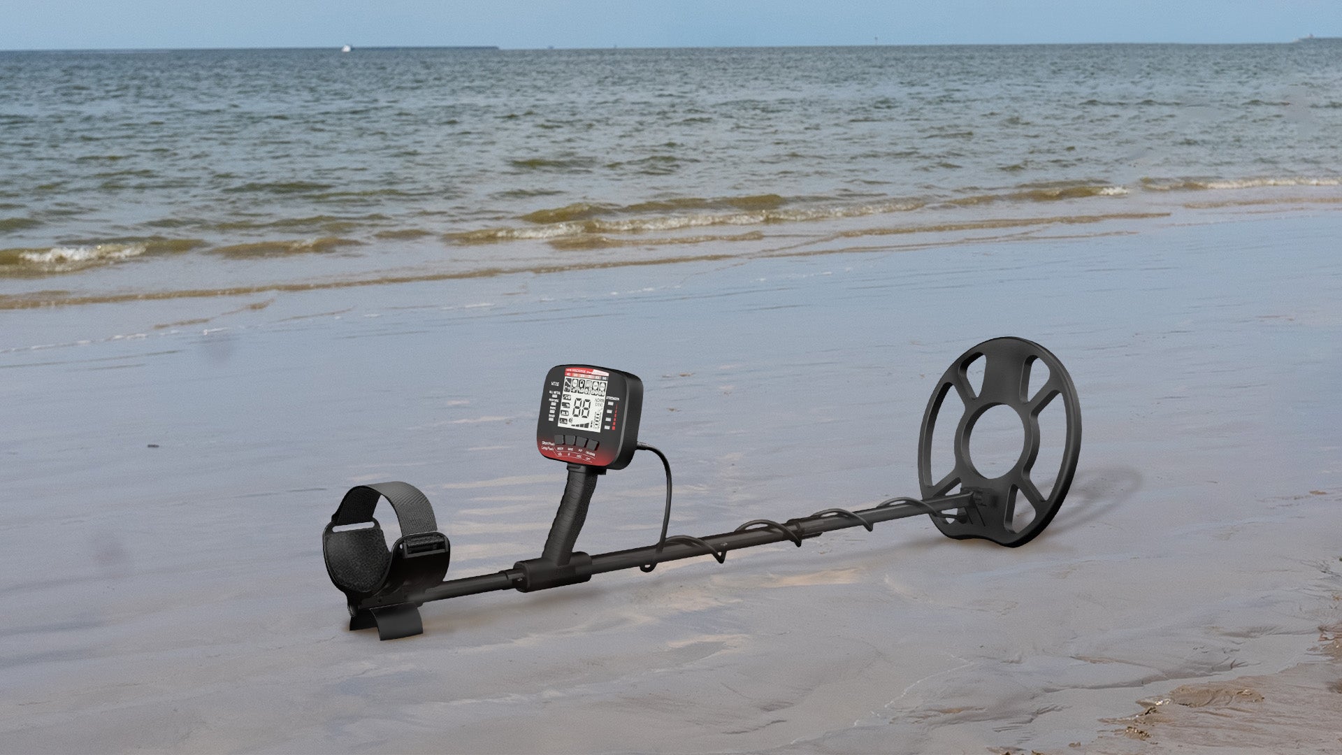 A metal detector lies on the sandy beach