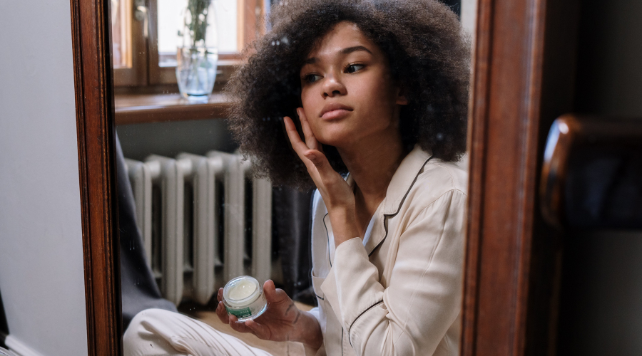 African American woman applying facial cream