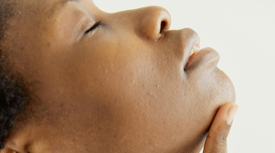Woman massaging her chin while applying skincare