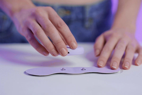 Applying the purple Aura TENS unit to the purple gel adhesive pads