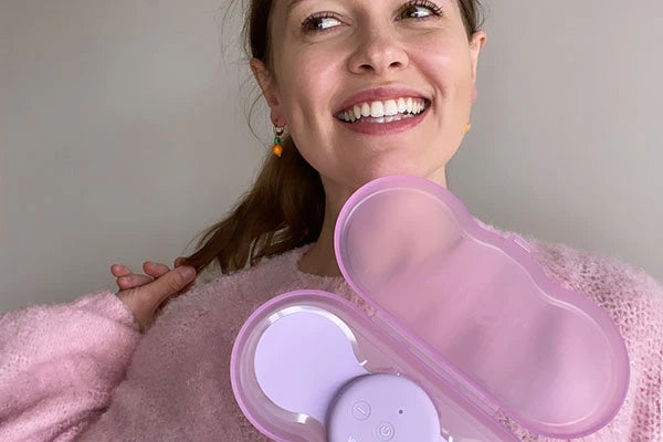 Bridget Hustwaite smiling and holding purple Aura TENS machine