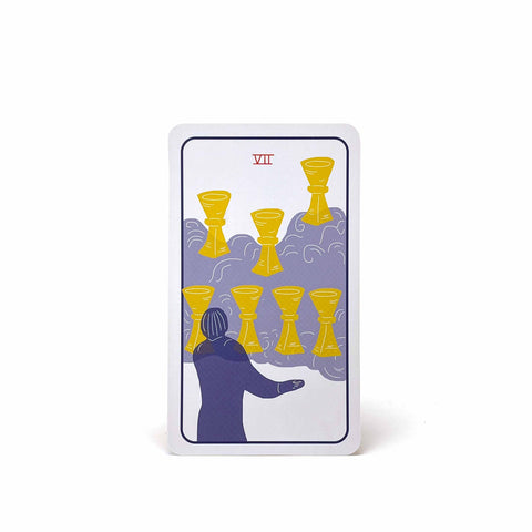 A tarot card with Roman numeral 7, showing a figure looking at 7 cups floating on a cloud.