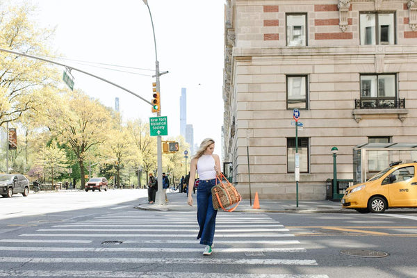 woman carrying a stylish Fawn Design diaper bag on the streets of New York