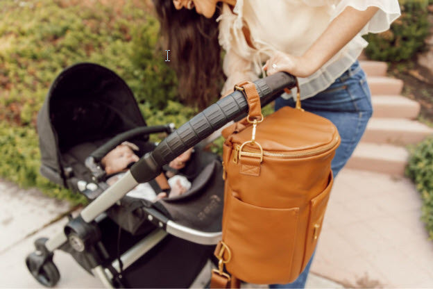 Woman with stylish bag pushing stroller