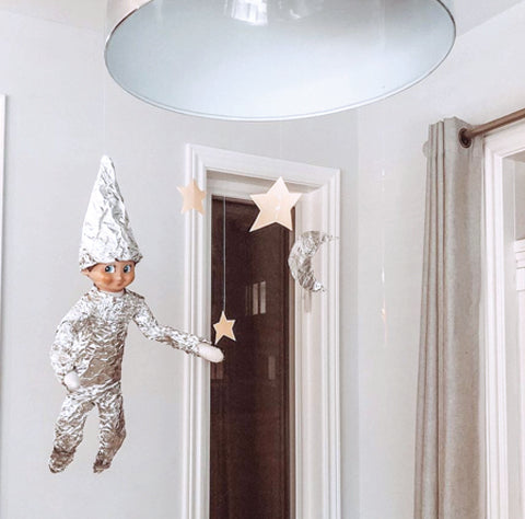 Elf in space suit hanging from light fixture