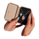 A GIF of manicured hands holding an open jewelry box with a necklace inside