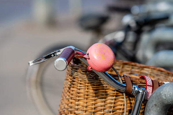 Pink bike bell on cruiser bike with wicker basket