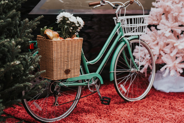 Green bike in front of holiday display with wicker pannier