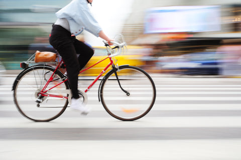 Women riding a red bike with crosswalk beneath her
