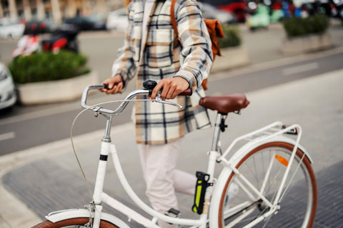 Woman walking white cruiser bike in the city