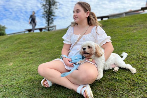 girl sitting on field with relaxed dog