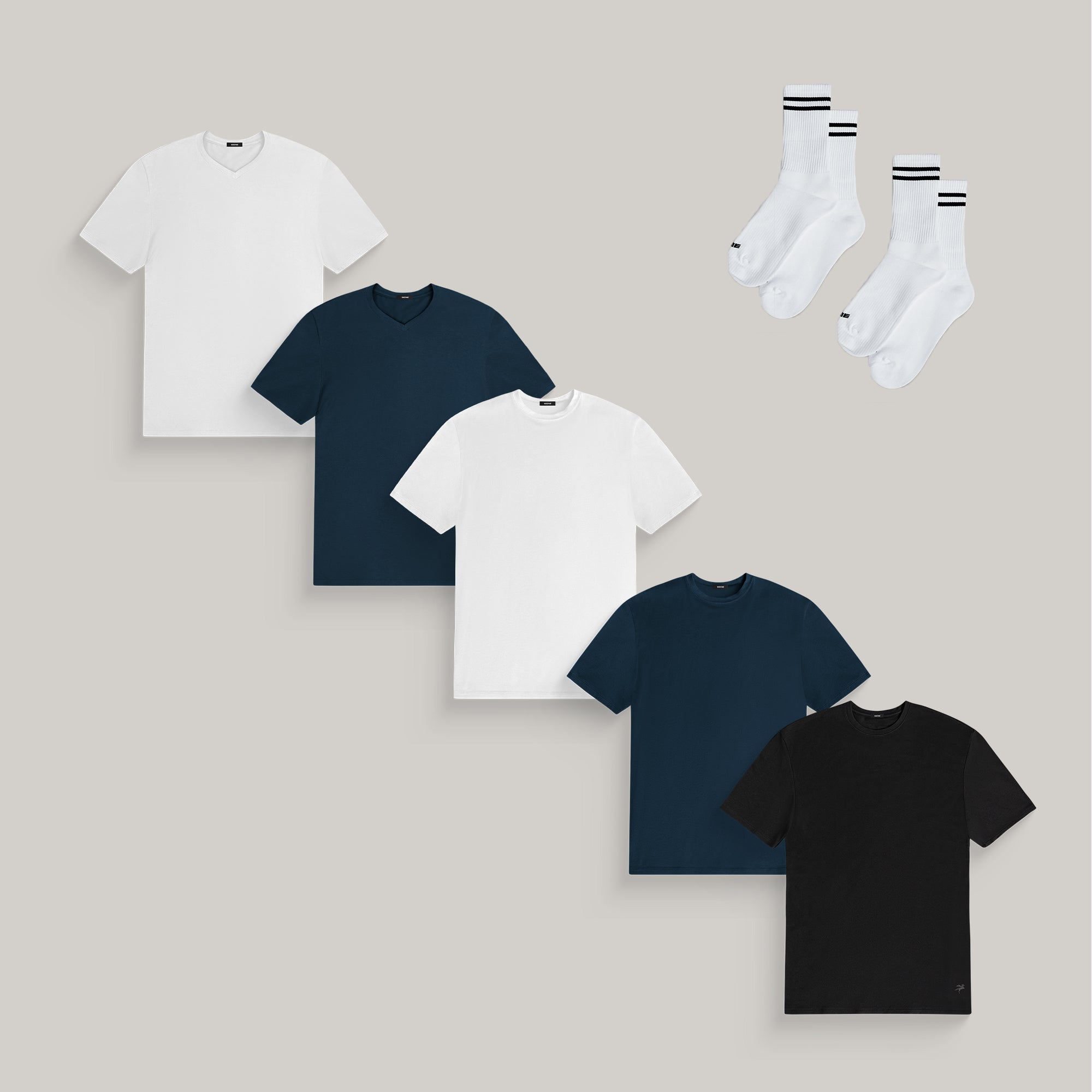 Five t-shirts in white, navy, and black with two pairs of white socks.