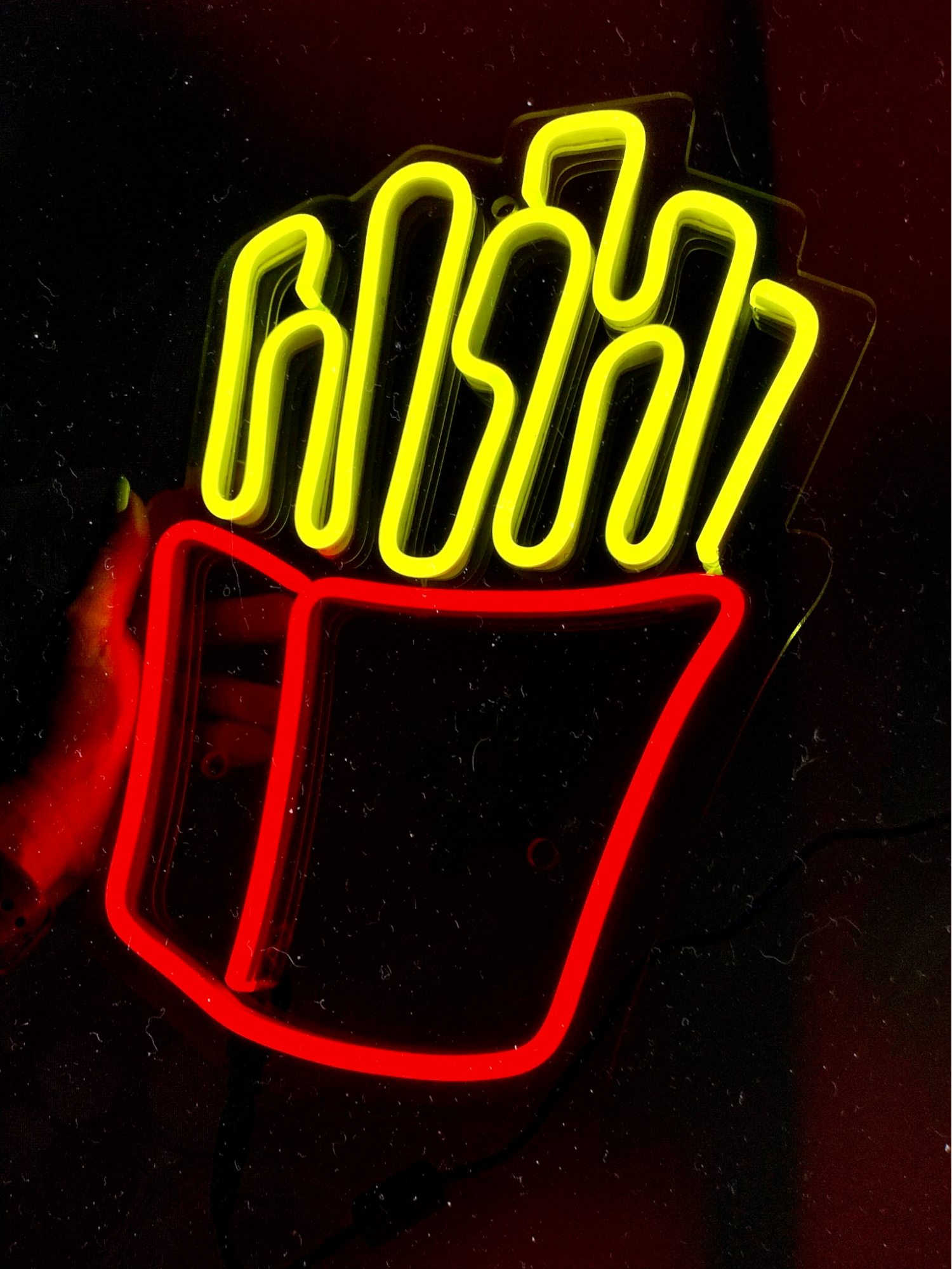 A neon sign advertising a French Fries