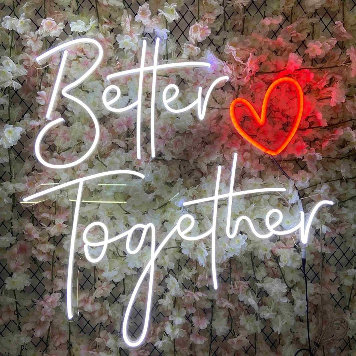 "Better Together" neon sign combined with a heart symbol