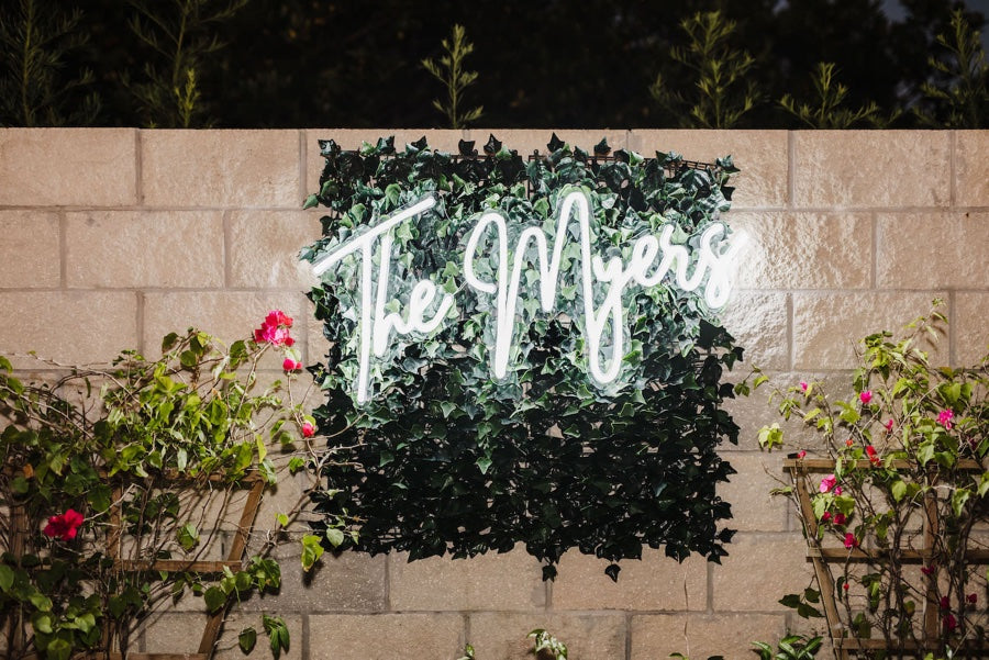 The Myers wedding neon sign hung on the focal point of the green wall