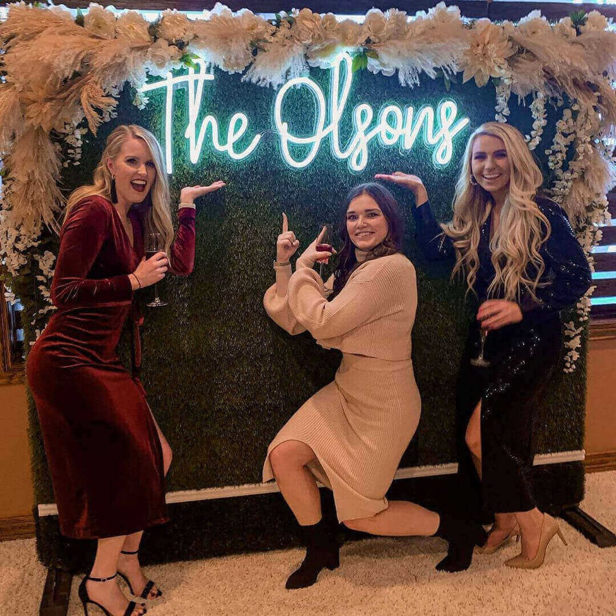 The Olson’s besties took photos with their wedding neon sign backdrop