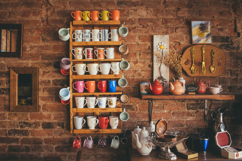 rustic wooden pegboard shelving unit hold in colorful cups and mugs
