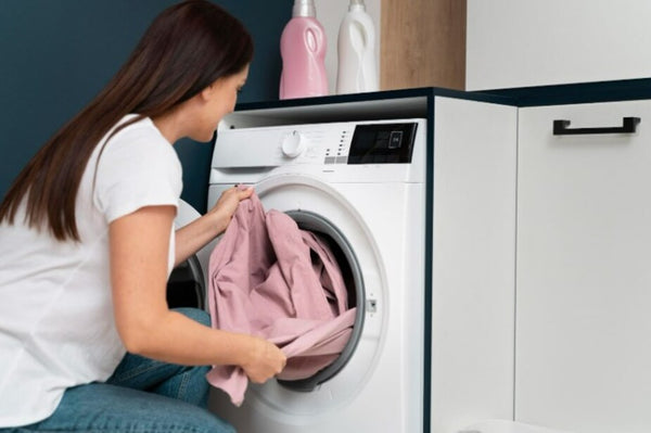 Mujer poniendo la lavadora en la despensa