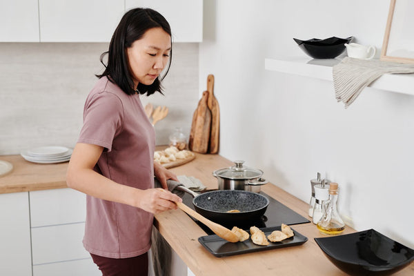 Woman cooking with a pan at home.