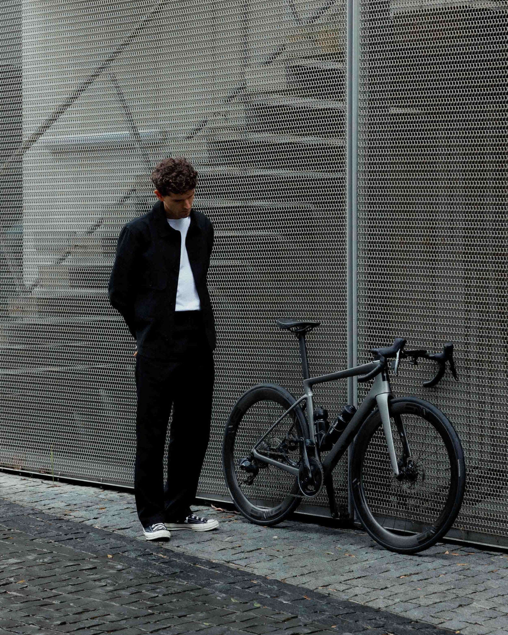Johnny pictured with bike wearing a black jacket, white t-shirt and black pants.