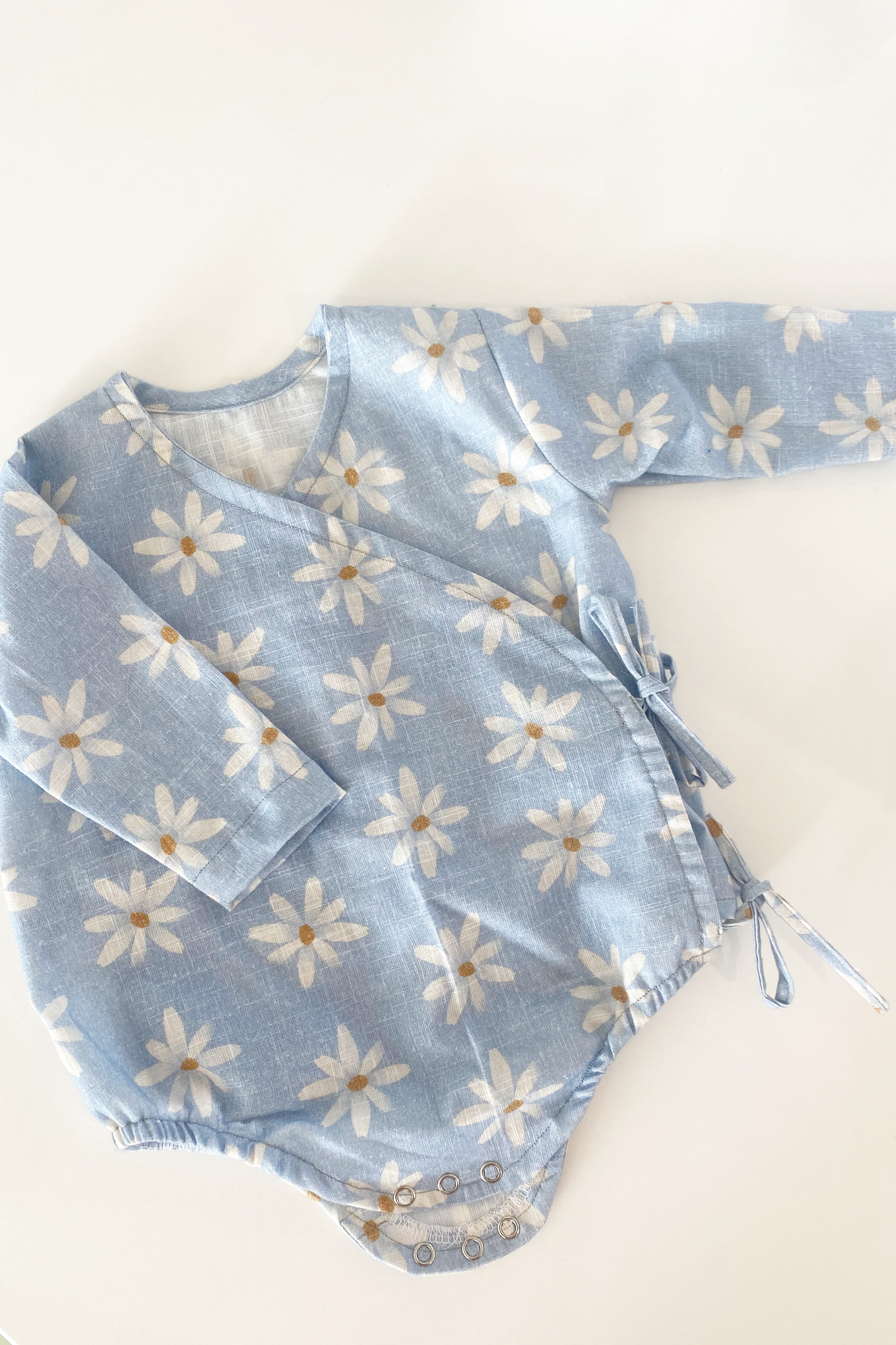A photo of a finished Baby Bellbird Romper and Top.