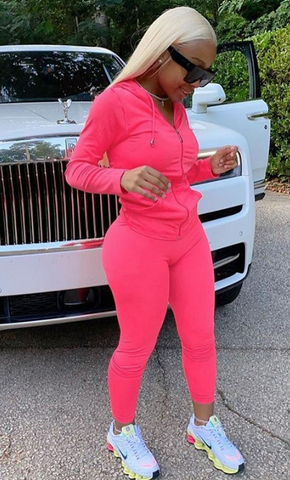 Pink 2 piece tracksuite streetwear set image with White Rolls Royce car in background.