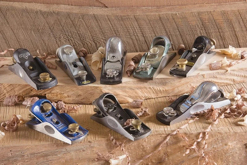 Collection of vintage and modern block planes, a versatile hand tool recommended for beginner woodworkers.
