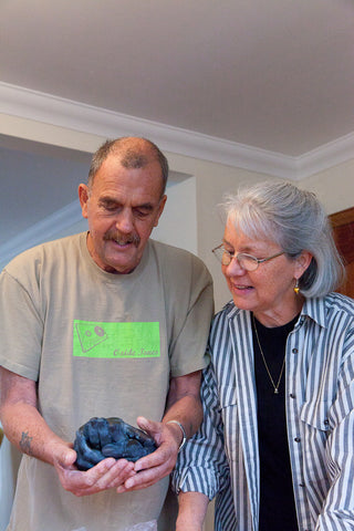 das ältere Ehepaar hält seine 3D Handabdrücke in Bronze Patina in den Händen