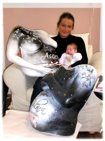 mutter mit baby und 2 gipsabdrücken vom babybauch in schwarz weiss design