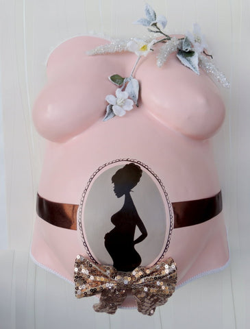 Ein rosa Gipsabdruck vom Babybauch mit schwangeren Silhoutte, Logo von Atelier Bodyparts