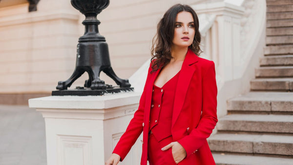 Elegant woman in a striking red blazer posing on a city street, a stylish clothing gift idea for her on Valentine's Day.