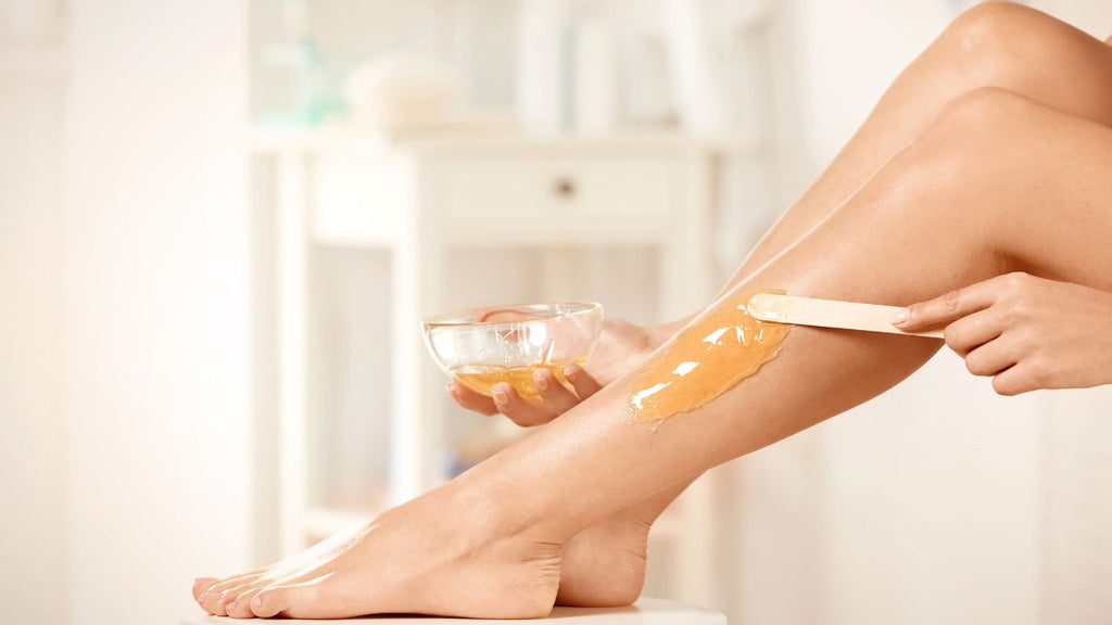 DIY sugaring hair removal process with a woman applying the paste on her leg.