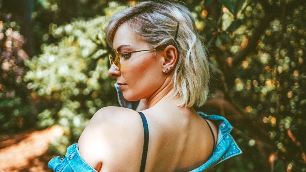 Profile of a blonde woman in sunglasses looking away thoughtfully.