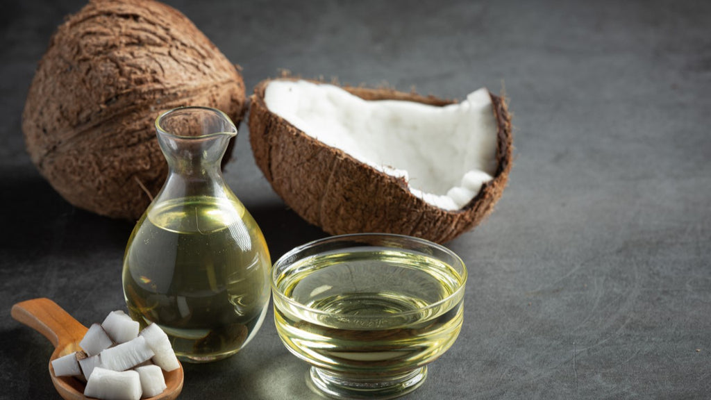 Coconut oil and fresh coconuts on a dark background, perfect for natural skin care and hydration.