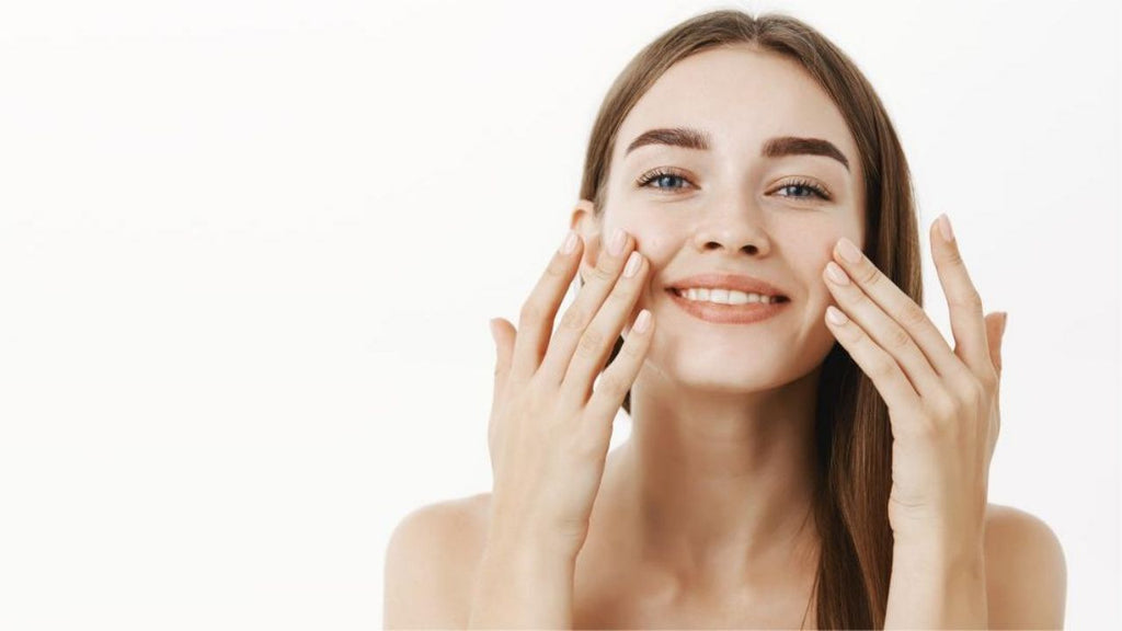 Joyful woman applying facial cream as part of her anti aging skincare routine.