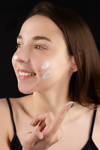 A woman applying cream