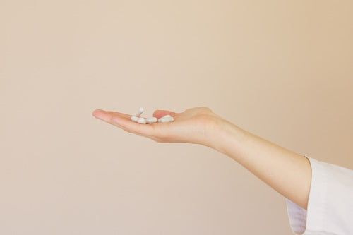 A person holding vitamin e pills